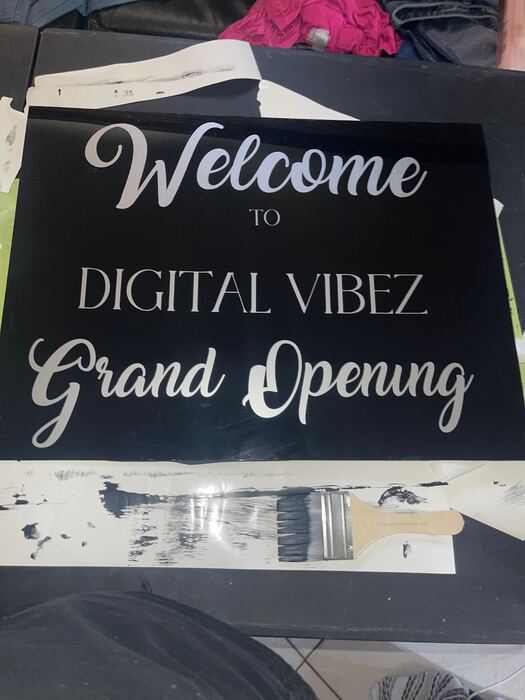Black acrylic grand opening welcome sign with silver lettering